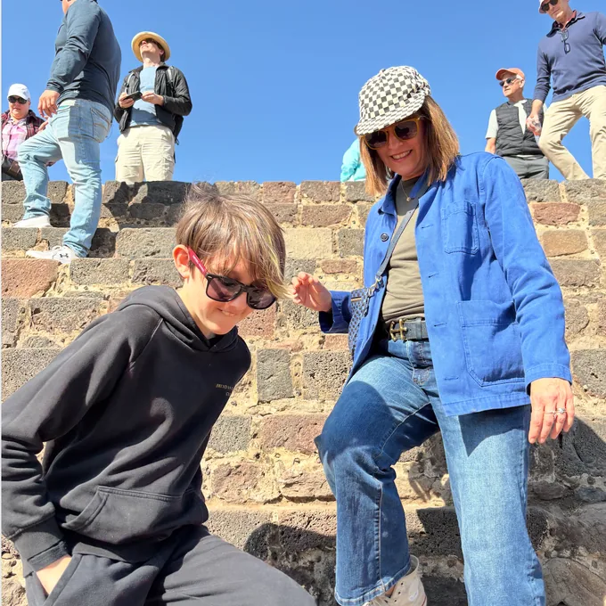 Allison and Theo on the stone steps of a pyramid at Teotihuacán, with other visitors climbing behind them.